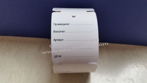Printed cardboard label on a roll with a hole for attachment to the product.